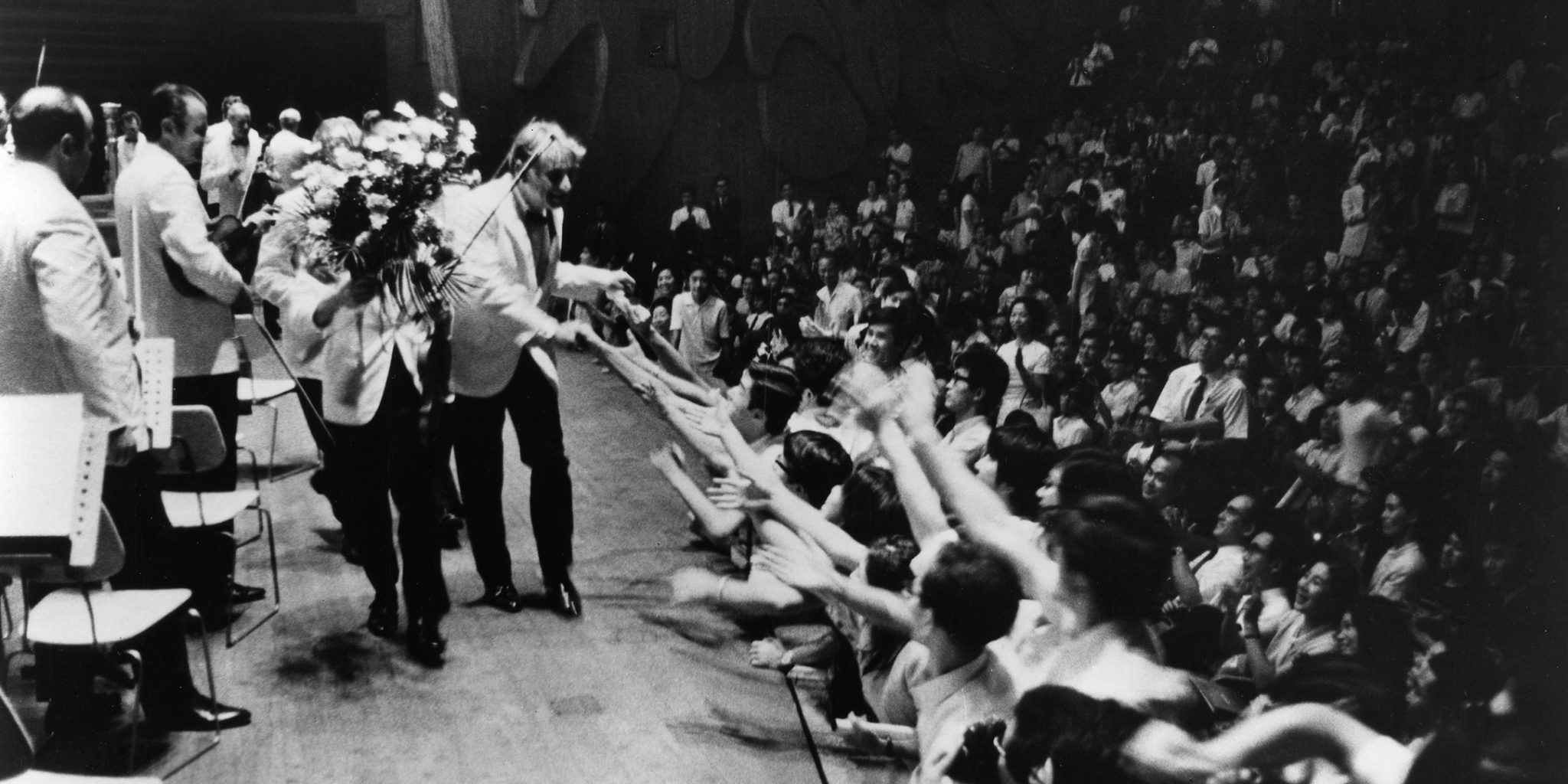 Leonard Bernstein se serre la main en sortant de scène. / Crédit : Archives de l'Orchestre philharmonique de New York